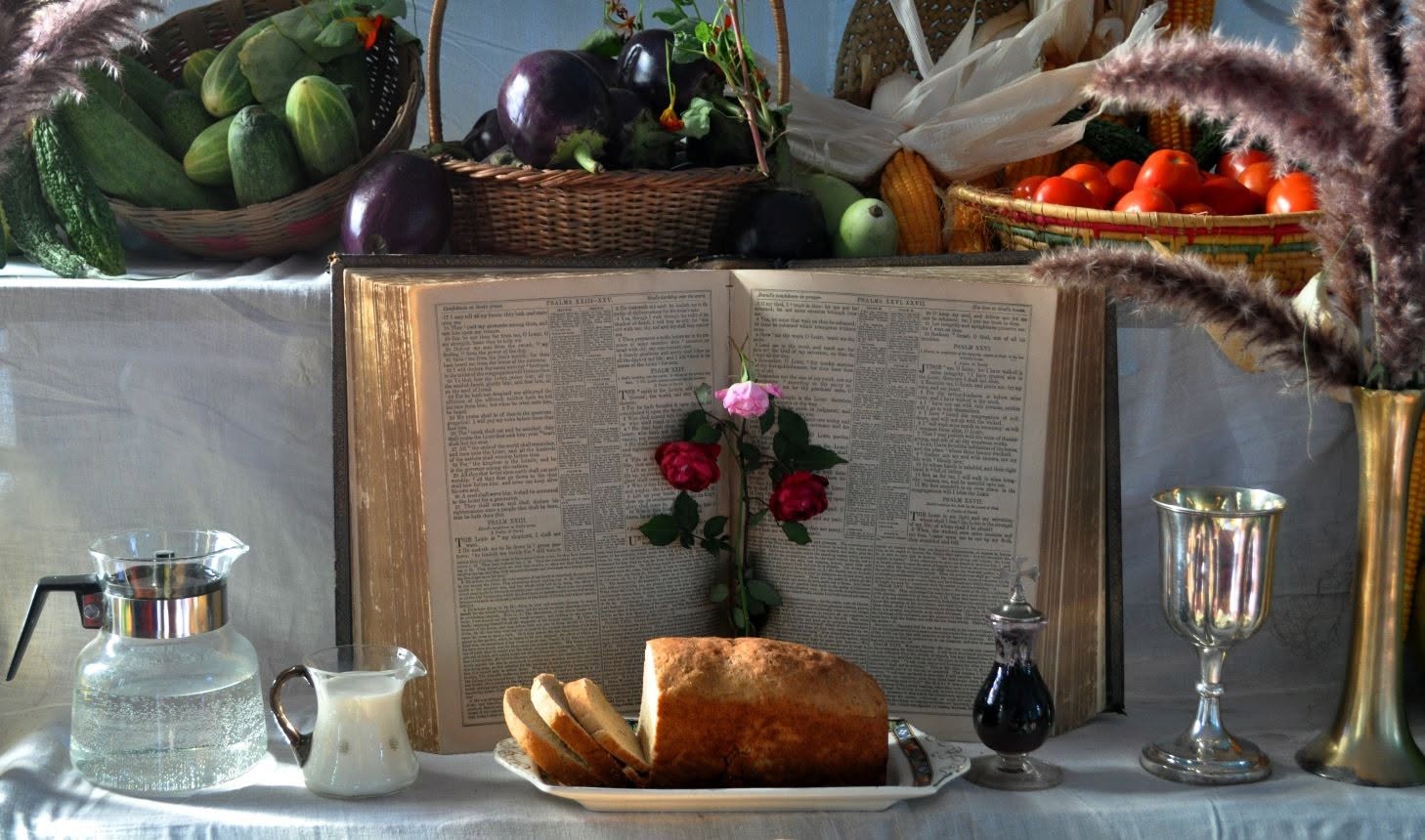 Communion table set with bread, wine and an open Bible for a harvest festival service