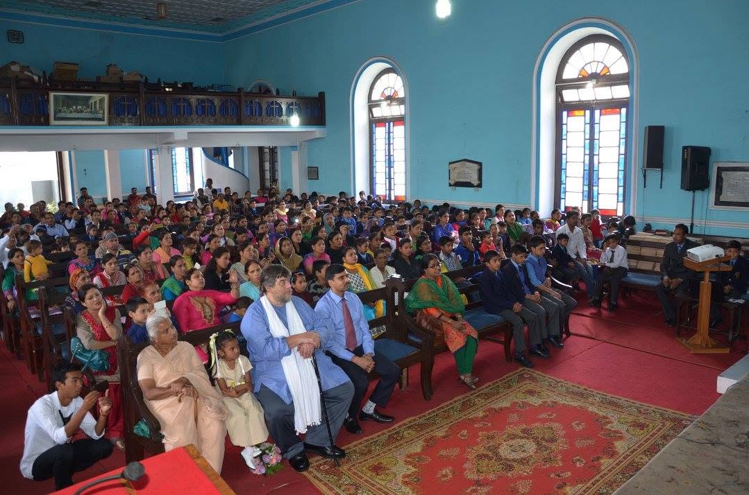 Congregation gathered for a service inside Union Church, beneath the stained glass windows
