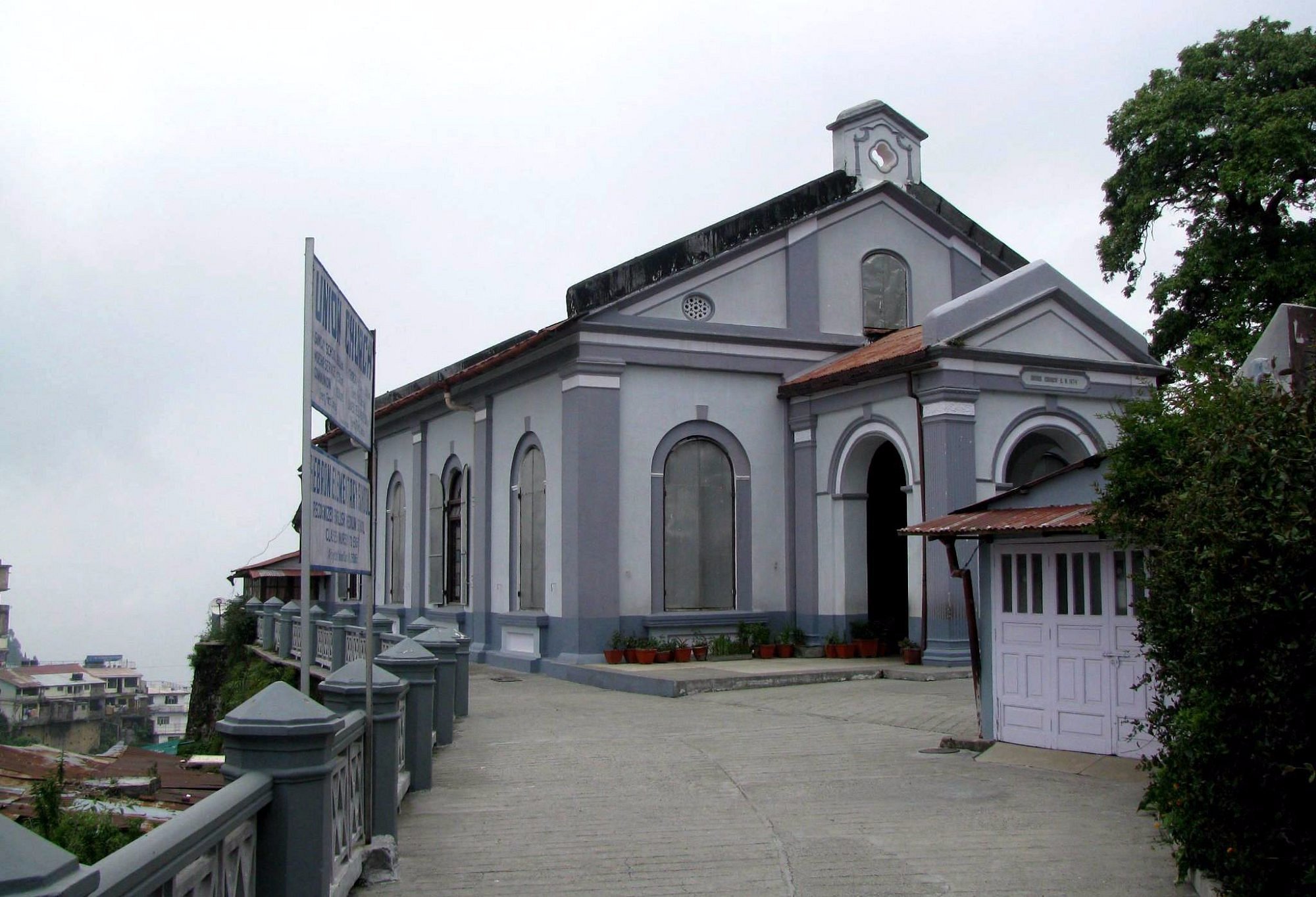 Union Church exterior, grey stone facade with arched windows and gate signage